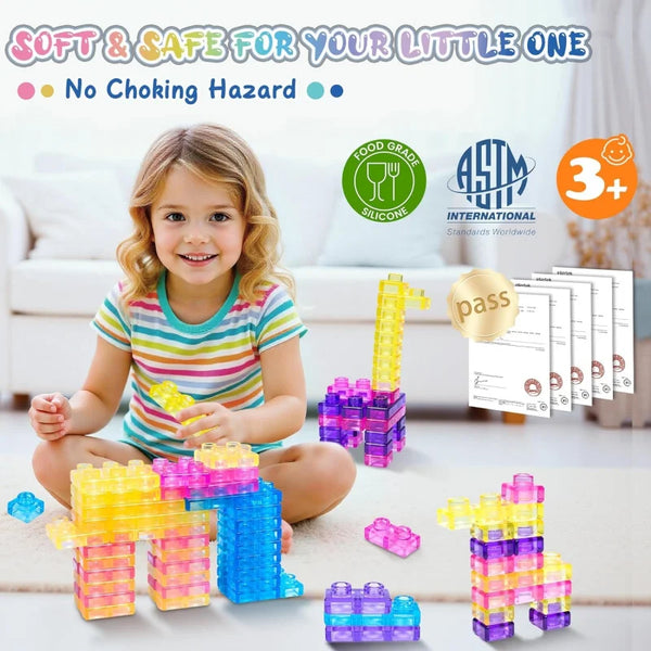 A young girl is playing with colorful silicone building blocks, including yellow, purple, and blue pieces.
