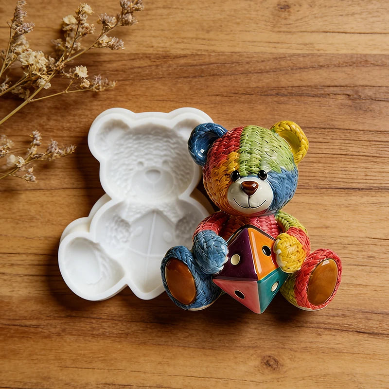 A colorful crochet texture teddy bear silicone mold resting on a wooden surface.