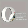 A protective film is shown being removed from the surface of a round acrylic wall sticker.