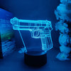 A glowing blue gun-shaped night light illuminates a dark background next to white flowers.