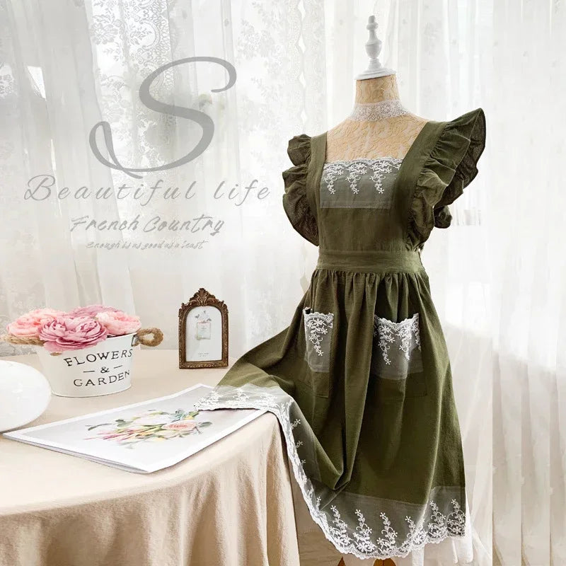 Moosgrünes Baumwoll-Leinen-Apronkleid mit Spitzenverzierung auf einem Mannequin.