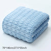 Light blue coral velvet bath towel folded on a white surface