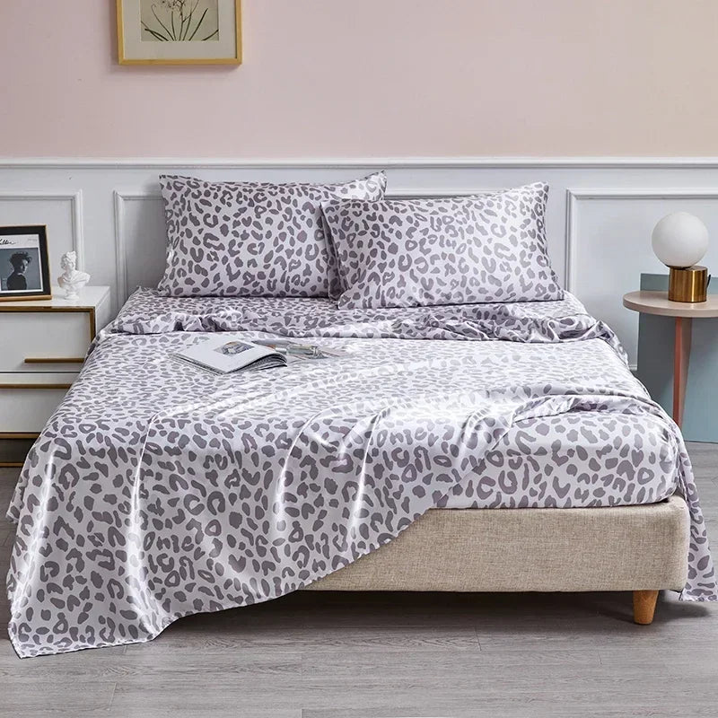 A luxury satin leopard print bedding set featuring gray and black spots on pillows and a duvet cover.