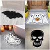A black decorative rug featuring a Halloween spider web and ghost design on a light floor.