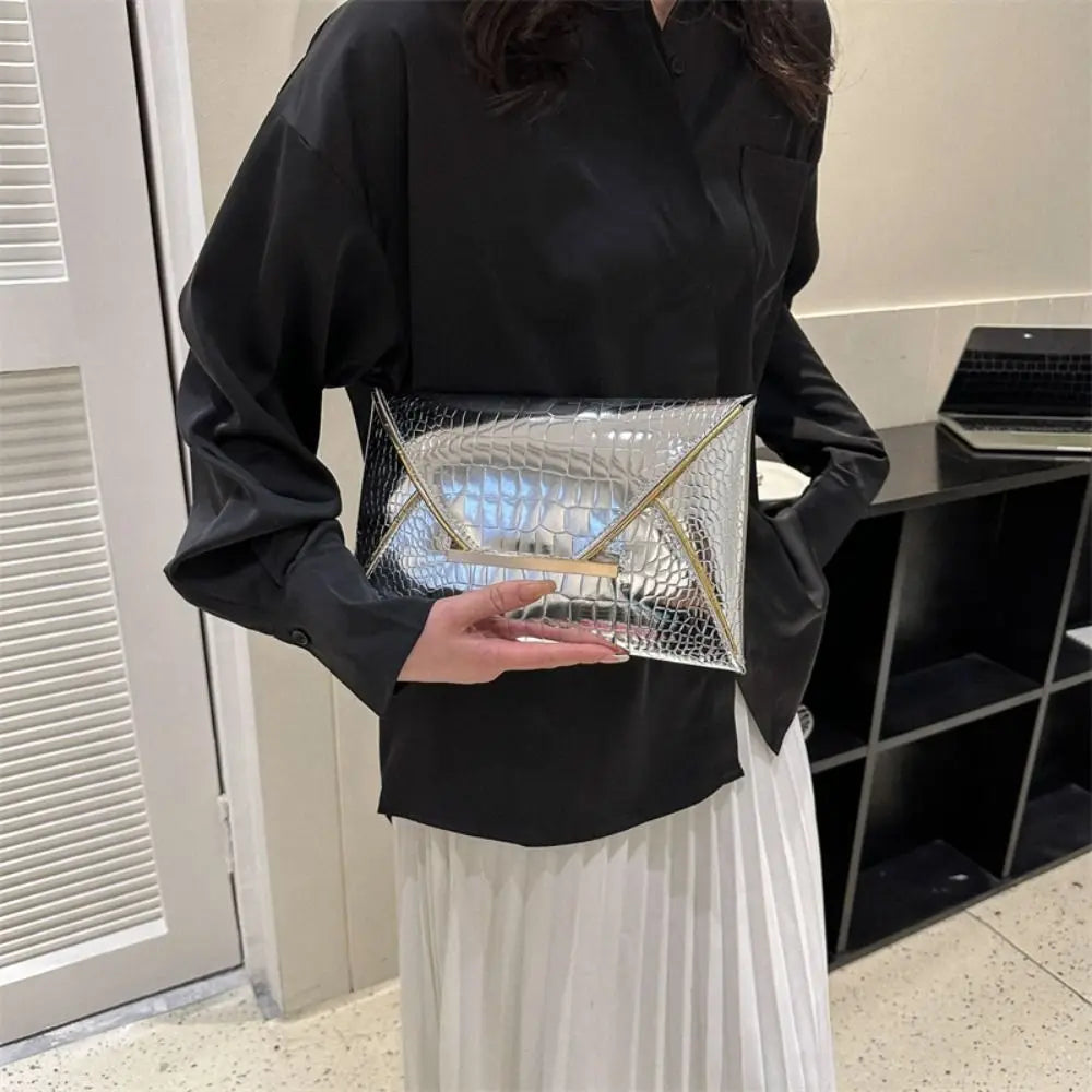 A woman holds a silver crocodile pattern PU envelope clutch with a coin pocket against a black shirt and white skirt.
