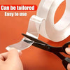 A hand is using a black tool to apply clear double-sided adhesive tape onto an orange background.