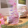 Roll of decorative PET tape featuring a pink and purple vine pattern for journaling and crafts