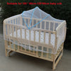 Wooden baby crib with a sheer mesh mosquito net covering the sides and top