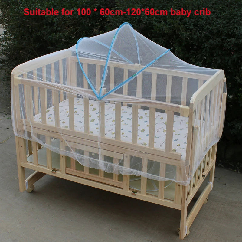 Wooden baby crib with a sheer mesh mosquito net covering the sides and top