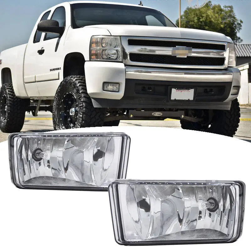 A close-up view of a white pickup truck with an aftermarket front bumper fog light assembly kit installed.