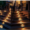 Outdoor stairs illuminated by solar powered LED lights on a wooden deck and railing.
