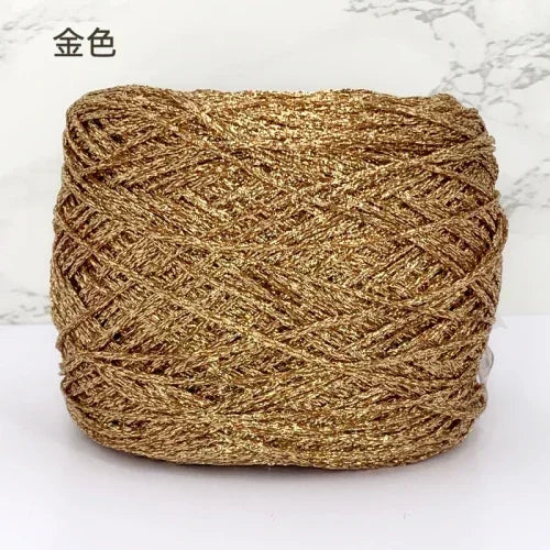A ball of metallic gold silk crochet yarn with a shimmering texture for knitting and macrame.