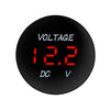 A round black digital voltmeter display showing 12.2 volts DC V.
