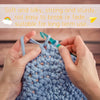 Hands knitting a light blue thick yarn for crafting