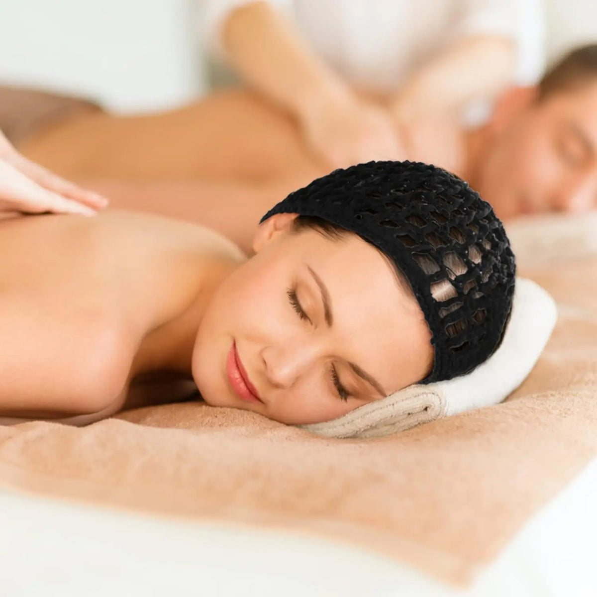 A woman is lying down with a black mesh crochet hair net placed under her head for sleeping or everyday wear.