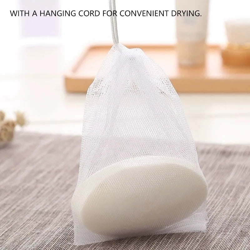 A white exfoliating foaming soap is visible inside a clear mesh bag with a hanging cord.