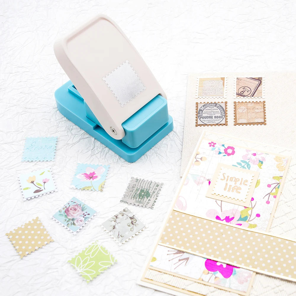 A light blue square postage stamp paper punch for crafting and scrapbooking is shown on a white surface.