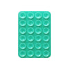 A green silicone suction pad with multiple circular indentations for phone mounts.