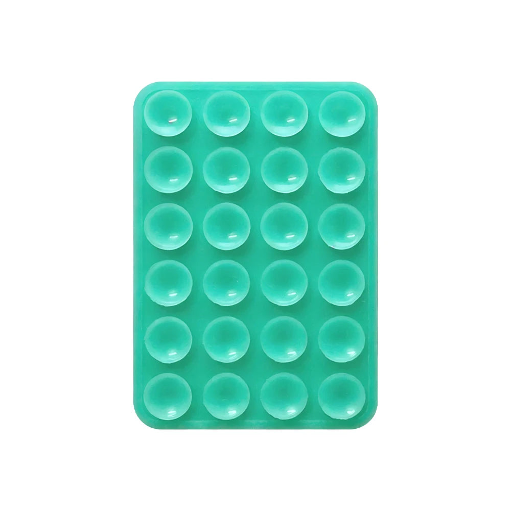 A green silicone suction pad with multiple circular indentations for phone mounts.