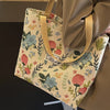 A beige corduroy tote bag with floral embroidery is shown hanging, featuring a light tan strap.