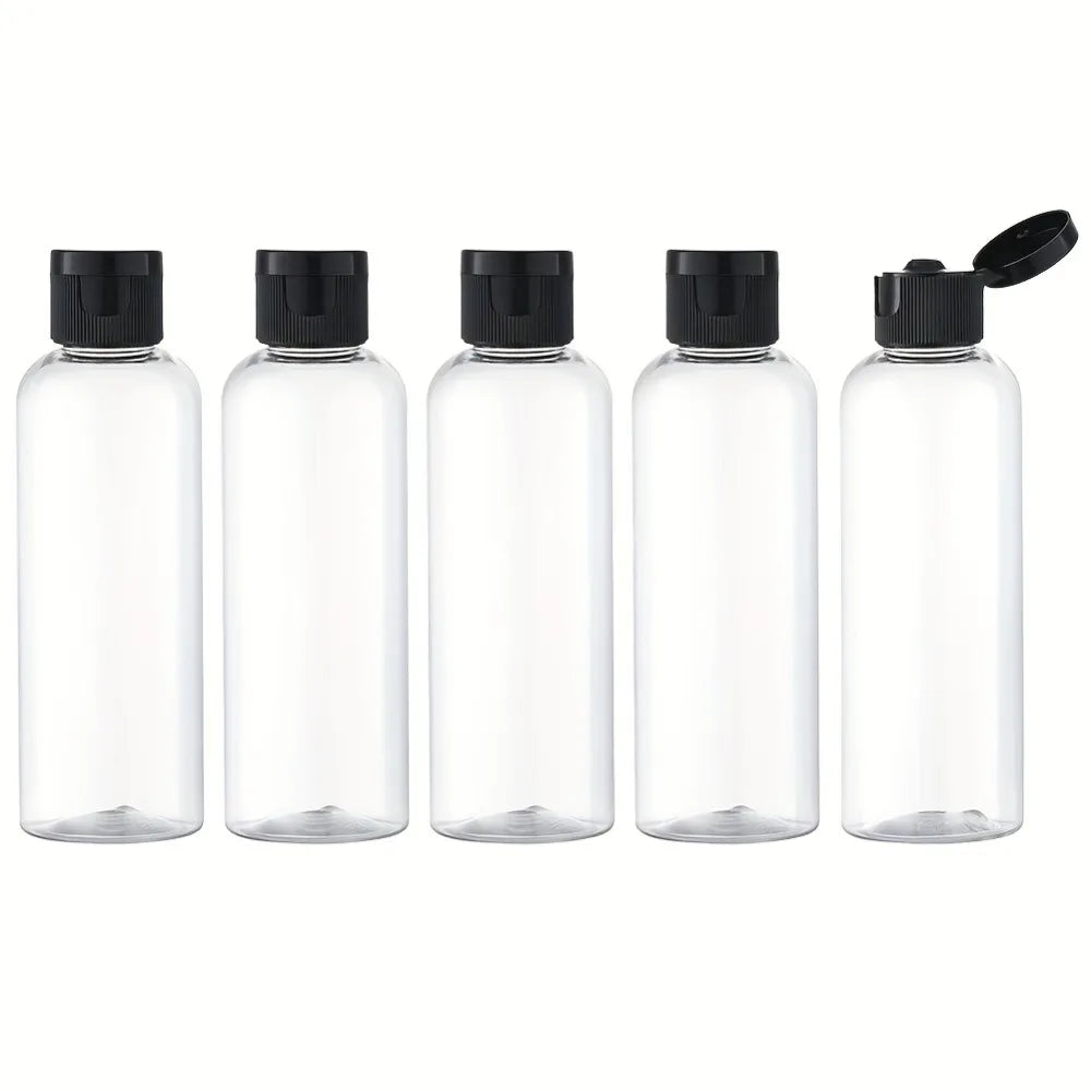 Five clear glass refillable travel bottles with flip caps arranged in a row.