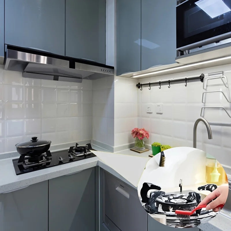 A kitchen counter shows a black and silver cleaning brush set with scraper tools next to white tiles and gray cabinets.