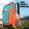An orange and blue hiking backpack is shown outdoors on a grassy field with mountains in the background.