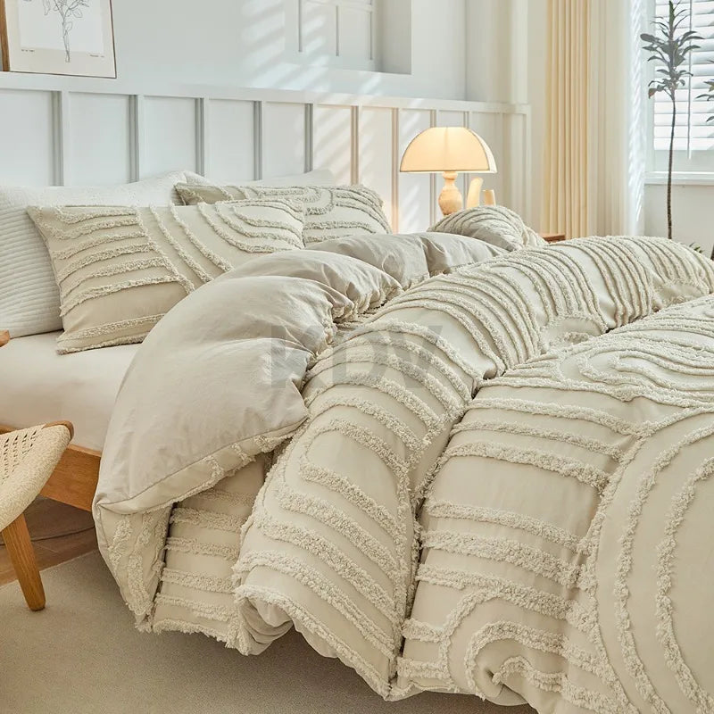 Beige bestickte Blumen-Bettwäsche-Set auf einem Bett mit hellem Holzakzenten und durchscheinenden Vorhängen.