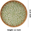 Round serving tray with a woven rattan rim and a pattern of green leaves inlaid into the surface.