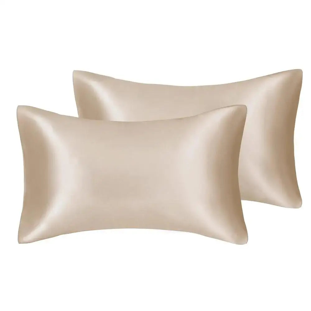 A pair of silky satin pillowcases in a champagne beige color.