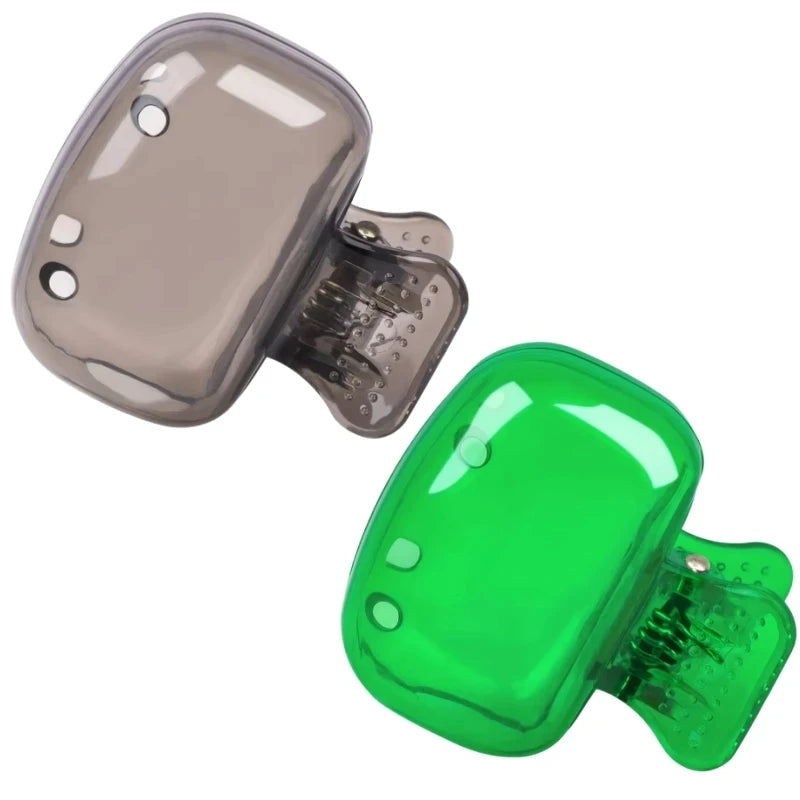 A pair of clear silicone toothbrush head covers with clips, one gray and one green.