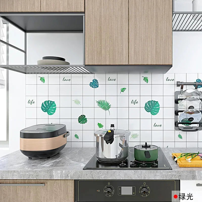 A kitchen countertop features a stainless steel pot and a green cooking pan against a white tiled splashback decorated with g
