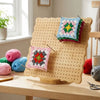 Holz-Strick-Blockierbrett-Set mit farbenfrohen gestrickten Quadraten und Häkelprojekten.
