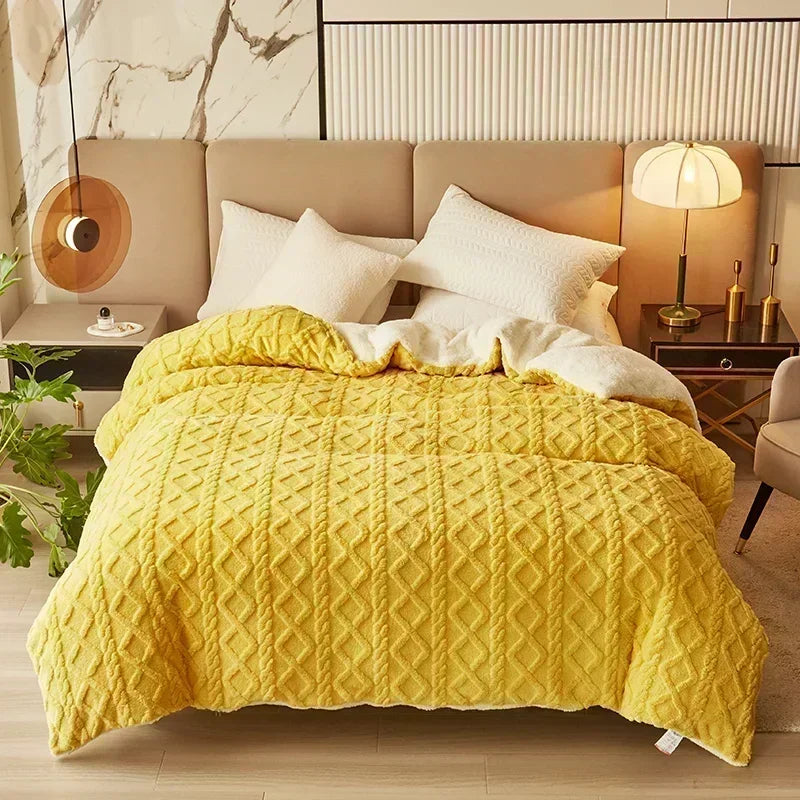 A bright yellow quilted duvet cover and blanket displayed on a bed with a neutral headboard.