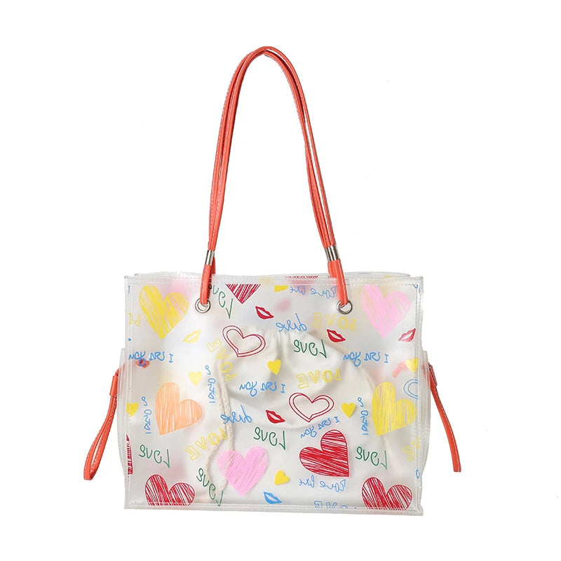 A clear plastic tote bag with orange handles and a decorative inner pouch featuring heart shapes.