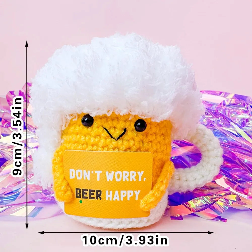 A handmade crochet pocket hug doll with a white fluffy hat and yellow body, displayed against a pink background.