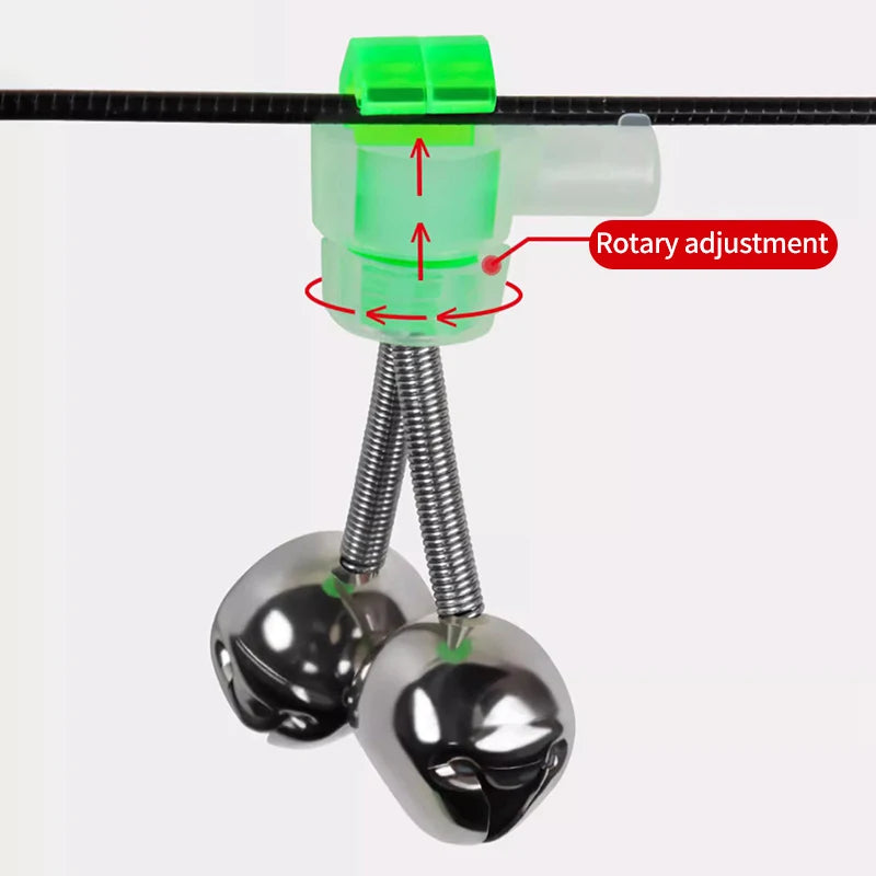 A close-up view of a fishing rod bite alarm bell with a clip-on indicator and a metal bell.