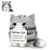 A gray knitted cat figurine with an inspirational card that reads Positive Cat You're Pure-fect