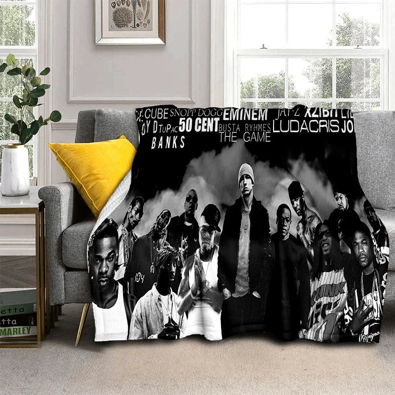 A throw blanket featuring a black and white photo collage of Eminem and Tupac.