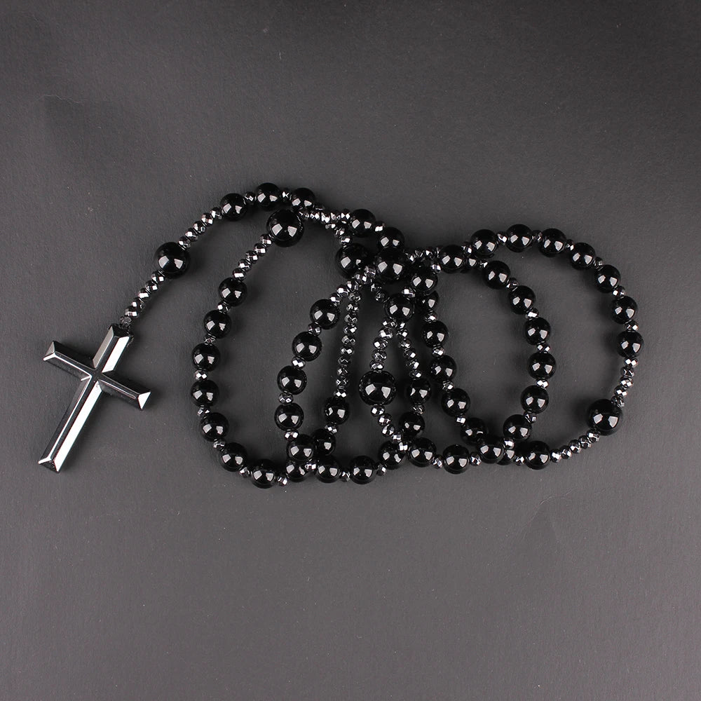 A necklace featuring a cross pendant made of tiger-eye stones and black beads.