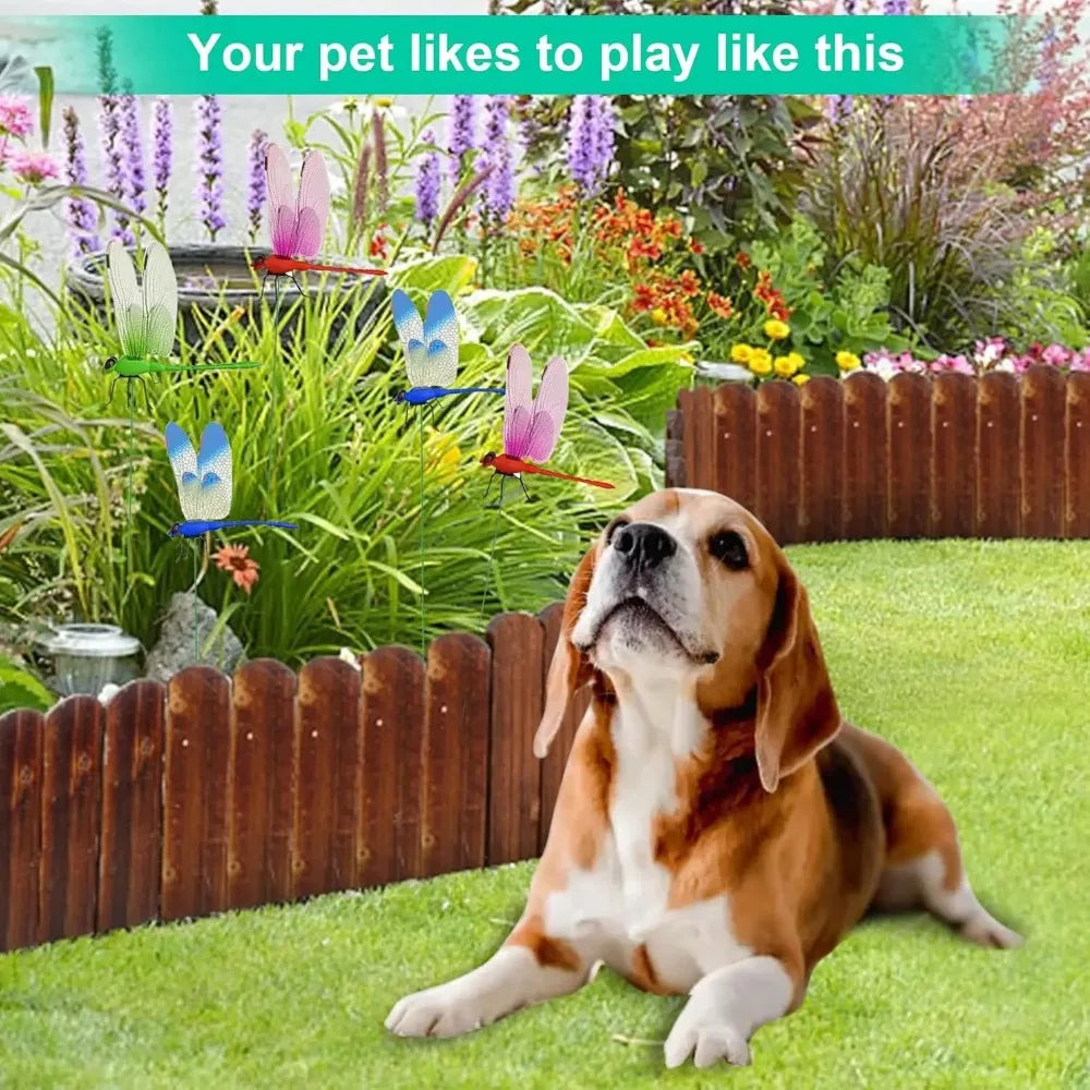 A beagle dog is lying on green grass in a garden setting with colorful flowers and dragonfly decor clips.