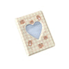 A light pink checkered photo album with a heart cutout and small bear illustrations.