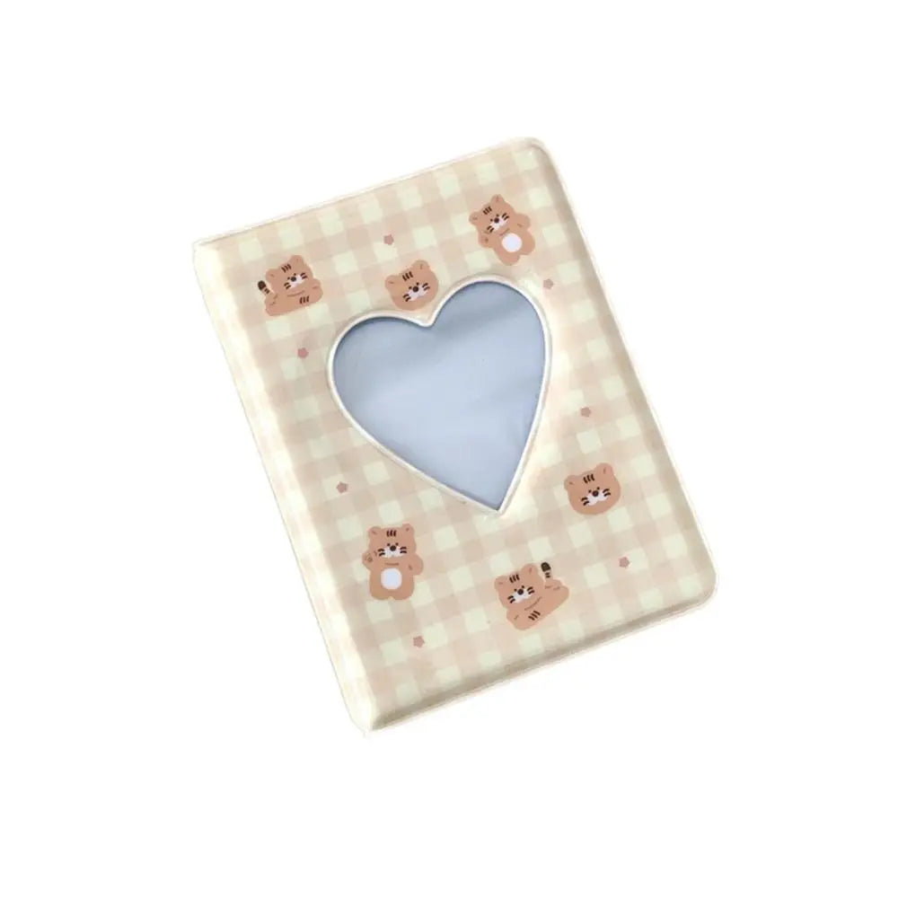 A light pink checkered photo album with a heart cutout and small bear illustrations.