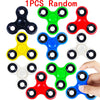 A collection of ten random color fidget spinners, including black, green, red, yellow, blue, and white.