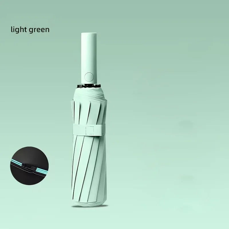A light green automatic windproof travel umbrella with a silver handle and black cap shown against a pale green background.