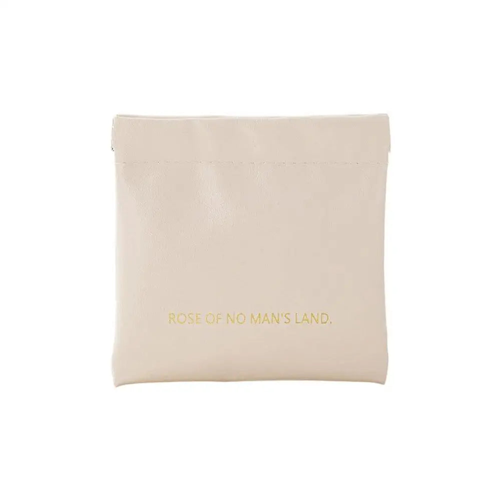 Pochette de voyage beige en PU compacte avec fermeture à ressort.