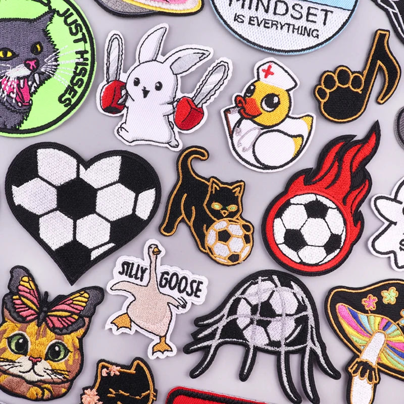 A collection of embroidered iron-on patches featuring funny cartoon animals like cats, rabbits, and geese.