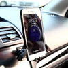 A smartphone displaying the time and date is mounted in a gravity car phone holder designed for vehicle vents.
