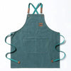 A teal cotton canvas apron with cross-back straps and multiple pockets.
