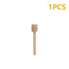 A single natural wood honey dipper stick with a wooden comb-like top.